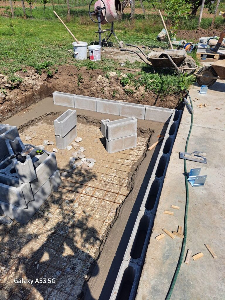 Betónová konštrukcia pri bielom dome a pergole – Malá obdĺžniková základová konštrukcia pri záhrade a poli Záber 2.