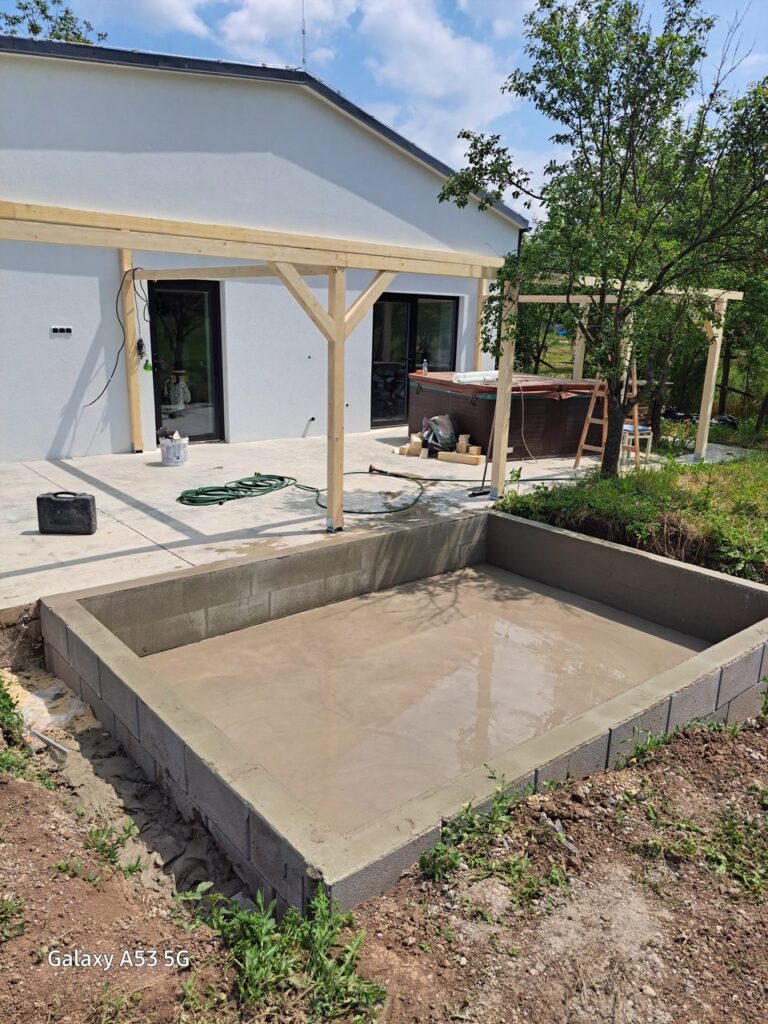 Betónová konštrukcia pri bielom dome a pergole – Malá obdĺžniková základová konštrukcia pri záhrade a poli Záber 6.