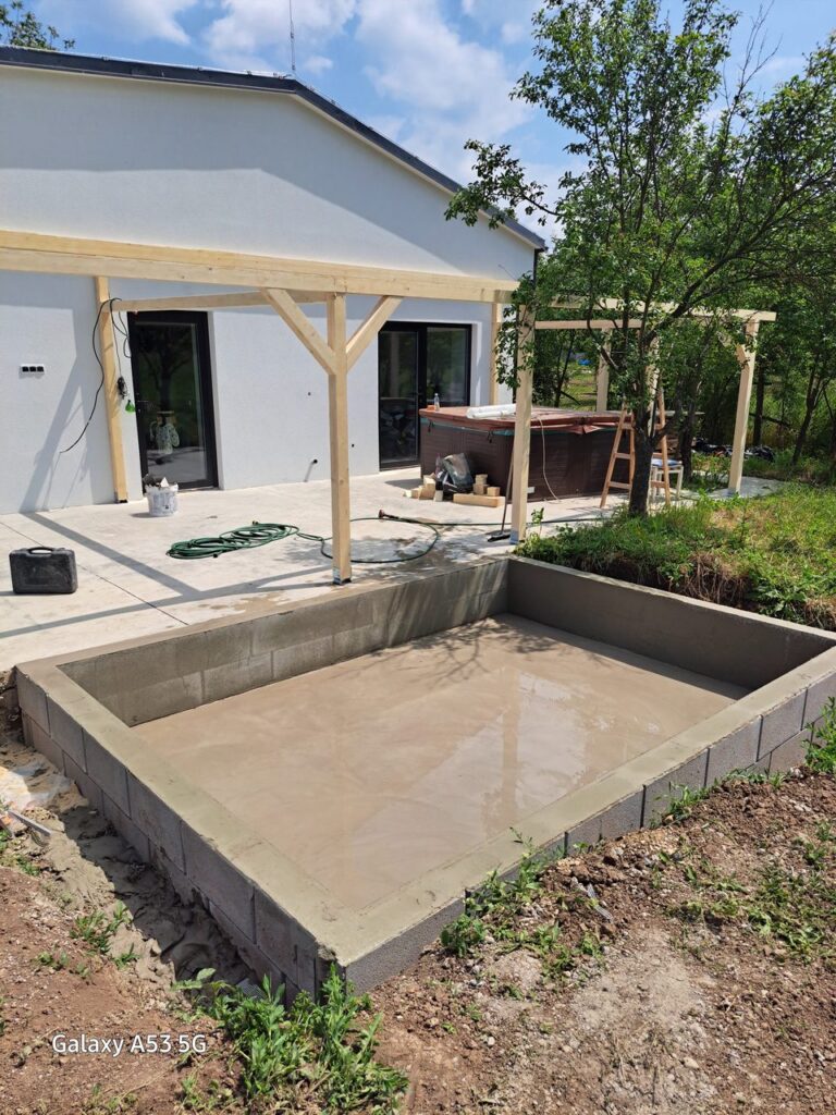 Betónová konštrukcia pri bielom dome a pergole – Malá obdĺžniková základová konštrukcia pri záhrade a poli Záber 7.